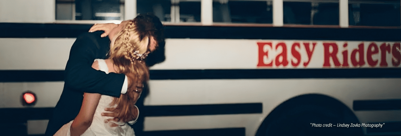 Couple kissing in front of bus